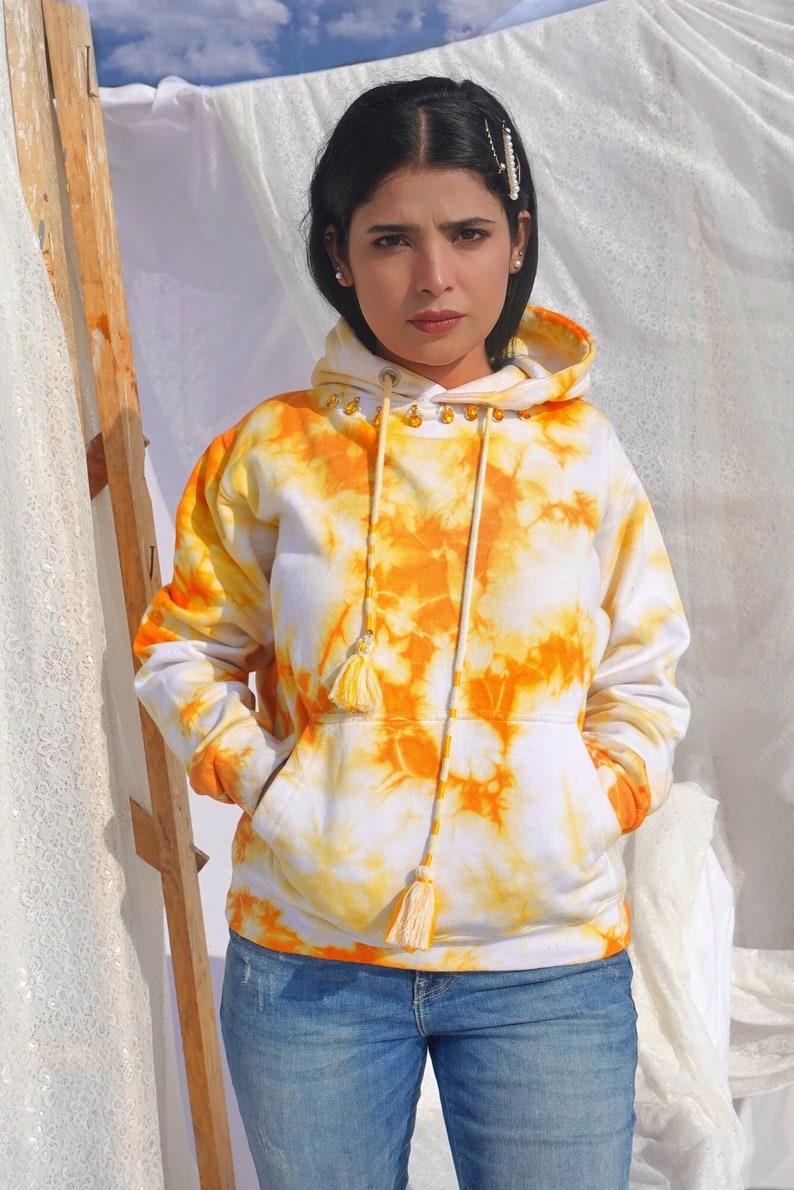 yellow and white tie dye fleece soft hoodie with rhinestone embellishment and tassel detailing on drawstrings .hooded sweatshirt