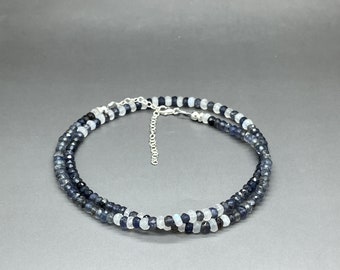 May include: A silver chain necklace with two strands of blue and white gemstone beads.