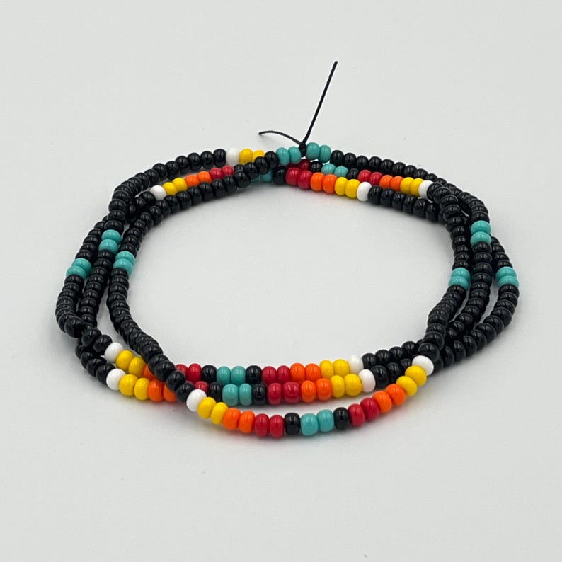 May include: A multi-strand beaded necklace with black, white, turquoise, orange, and red beads.