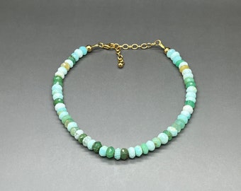 May include: A delicate gold chain anklet with a graduated strand of light blue and green gemstone beads.