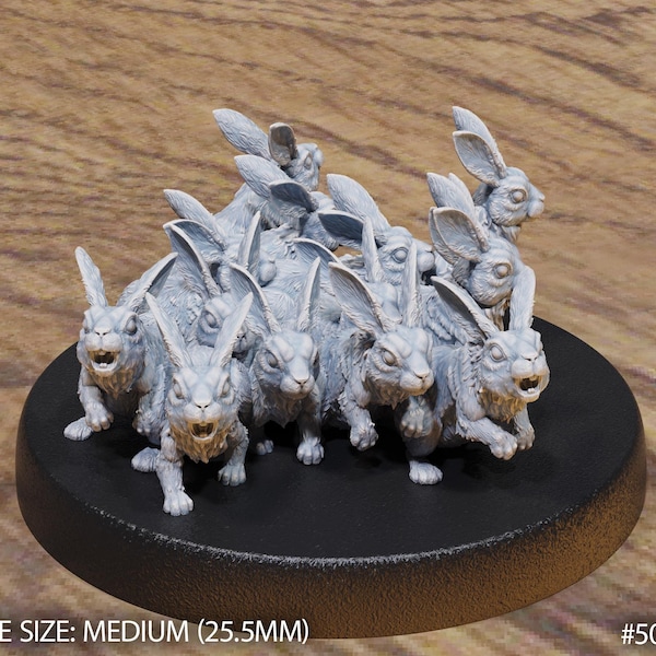 May include: A group of 12 grey, detailed, miniature rabbit figurines with long ears, standing on a black circular base. The base is labeled "BASE SIZE: MEDIUM (25.5MM)" and "#5068".