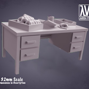 May include: A grey, 32mm scale model of a desk with two drawers on each side and a top surface with a box of doughnuts, a roll of tape, and a small tray. The desk is made of plastic and is designed for tabletop gaming.