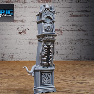 May include: A gray miniature grandfather clock with intricate details, including a round clock face, ornate carvings, and a stylized monster mouth. The clock has an elephant trunk-like appendage. The logo "EPIC Miniatures" is in the upper left corner.