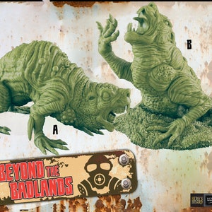 May include: Two green, detailed, plastic miniatures of mutated creatures from the Beyond the Badlands game. The creatures are in a snarling, attacking pose. The miniatures are labeled A and B.
