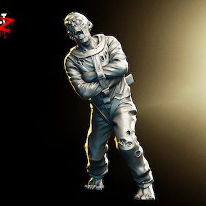 May include: A gray, detailed miniature figurine of a zombie wearing a straitjacket. The zombie has a distressed look on its face and is posed in a standing position with its arms bound.