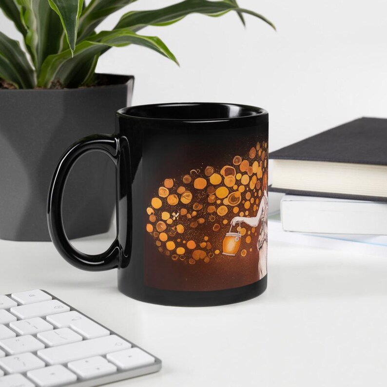 May include: A black ceramic mug featuring a whimsical illustration. The design depicts a figure holding a lantern, surrounded by glowing orbs. The mug has a glossy finish and a large, curved handle.