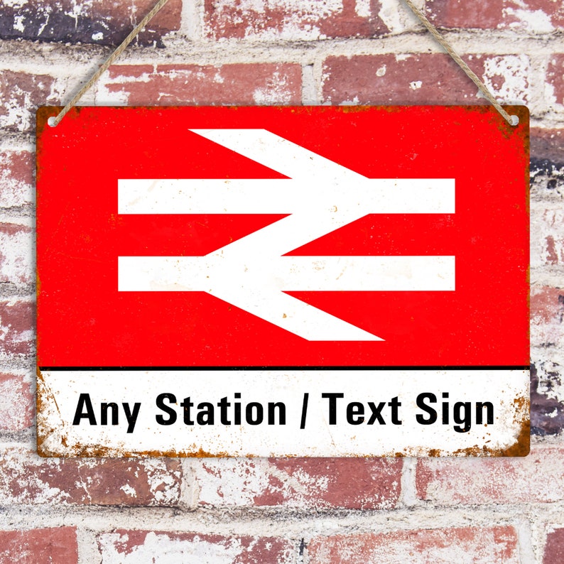 May include: A red and white metal sign with the text "Any Station / Text Sign" and a white stylized logo of a railway symbol. The sign has a distressed, rusty look.