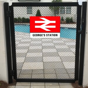 May include: A black metal gate with a red and white sign that says "GEORGE'S STATION" and a white symbol with two diagonal lines and an arrow pointing to the right. The gate is in front of a swimming pool.