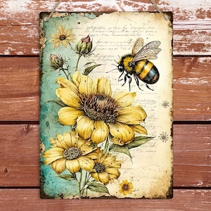 May include: A rectangular metal sign with a watercolour illustration of a bumblebee and sunflowers. The bee is black and yellow, and the flowers are yellow with brown centres. The background has a vintage, distressed appearance with script.