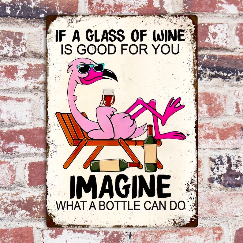 Puede incluir: Un flamenco rosa con gafas de sol se relaja en una tumbona con una copa de vino. El texto en el cartel dice "Si un vaso de vino es bueno para ti, imagina lo que puede hacer una botella."