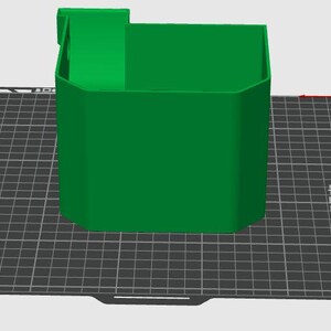 May include: A 3D rendered green container with an open top and a rectangular extension on one side. The object is positioned on a dark gray grid surface labeled Bambu Textured PEI Plate, featuring a coordinate axis indicator in the upper right corner.