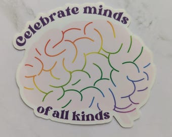 May include: A die-cut sticker featuring a light pink brain illustration with rainbow-colored outlines of the brain's sulci. The text "Celebrate minds of all kinds" is printed in dark purple, arched above and below the brain graphic.