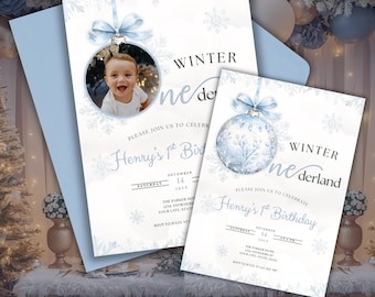 May include: Two light blue winter-themed birthday invitations. One features a photo of a baby in a round ornament, the other a decorative ornament. Both have the text "Winter Wonderland" and "Henry's 1st Birthday".