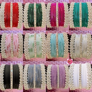 May include: A selection of vibrant bangles in shades like red, green, pink, and turquoise. Each set features a decorative silver border and a central line of sparkling embellishments. The bangles are displayed in a grid arrangement, showcasing their diverse colours.