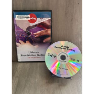 May include: A DVD case and disc for "Ultimate Free-Motion Quilting with Patsy Thompson." The case features a sewing machine and hands, with the Craftsy logo. The disc has the same title and Craftsy branding.