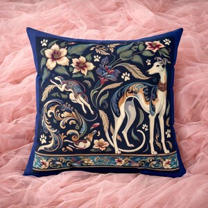 May include: A square throw pillow featuring a dark blue background with a repeating pattern of greyhound dogs, floral motifs, and small paw prints. The design includes a leaping greyhound, a standing greyhound, and a decorative border at the bottom.