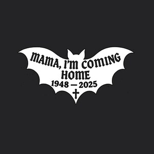 Puede incluir: Un dise&ntilde;o blanco en forma de murci&eacute;lago con el texto "MAMA, I'M COMING HOME" y los a&ntilde;os "1948-2025" con un s&iacute;mbolo de cruz, sobre un fondo negro. El dise&ntilde;o tiene un tema g&oacute;tico o de Halloween.