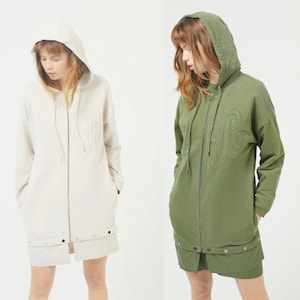 May include: Two hooded sweatshirts with a large embroidered letter "R" on the front. One sweatshirt is beige and the other is green.