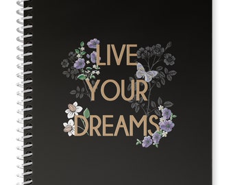 Elegante cuaderno de espiral de tapa dura negro de 17 x 24 cm, 200 páginas interiores punteadas, 90 g/m² de grosor. Mensaje con el eslogan "VIVE TUS SUEÑOS".