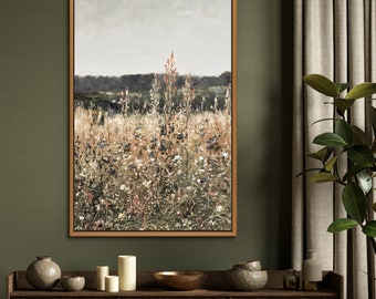 May include: A framed canvas print of a landscape painting featuring a field of wildflowers in shades of green, brown, and white. The painting has a soft, muted color palette and a dreamy, ethereal feel.
