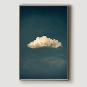 May include: A single, fluffy white cloud against a dark blue sky. The cloud is in the center of the image and is the only visible cloud.