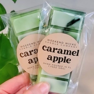 May include: Two packages of caramel apple scented wax melts. Each package contains five light green wax melt bars. The packages are sealed in clear plastic and have a round label with the text "Caramel Apple" and "Weekend Wicks Candle Company".
