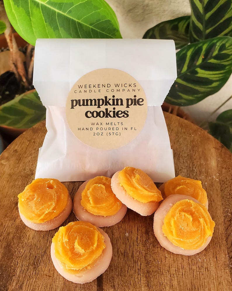 May include: Six round, orange-colored wax melts with a swirl design, labeled "pumpkin pie cookies" and "Weekend Wicks Candle Company".