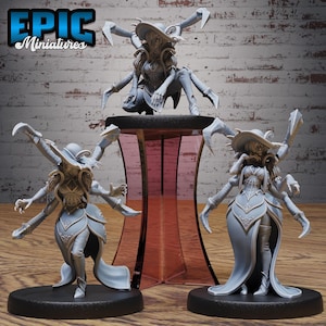 May include: Three gray miniature figurines of a fantasy character with spider-like appendages. The figures are on black bases, with one figure on a red-tinted display stand. The figurines are wearing a hat and dress.