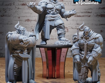May include: Three gray miniature fantasy figures. One figure stands on a pedestal, arms outstretched. Two other figures stand on black bases, one holding a sword. The figures are muscular and detailed, with horned helmets and armor. The text "EPIC Miniatures" is in the upper right corner.
