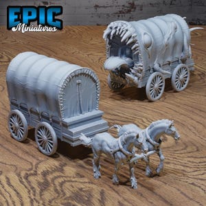 May include: Two grey painted miniature wagons, one with a canvas top and the other with a monstrous, toothy mouth. Both wagons have wheels and are pulled by two grey horses.