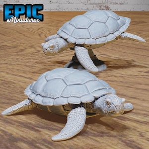 May include: Two gray painted turtle figurines. The turtles are in a walking pose with their heads up and their legs extended. The turtles are made of a smooth, hard plastic.