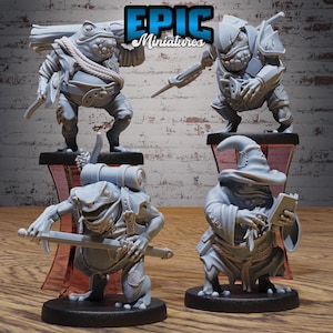 May include: Four grey frog figurines in different poses, each on a black base. One frog carries a sword, another a backpack, and a third wears armour. The fourth frog wears a wizard's hat and robe, holding a book. The text "EPIC Miniatures" is at the top.