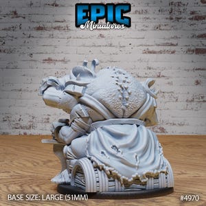 May include: A gray, detailed miniature of a goblin sitting on a throne with a large, tattered cape. The miniature is on a round base with the text "BASE SIZE: LARGE (51MM)" and "#4970" printed on the base.
