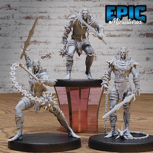 May include: Three gray painted miniature figurines of elves, each with a different weapon. The elf on the left is holding a spiked chain, the elf in the middle is holding a sword, and the elf on the right is holding a sword and a spiked chain.