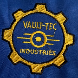 May include: A yellow and black embroidered patch with the text "Vault-Tec Industries" and a stylized symbol of three glowing rods.