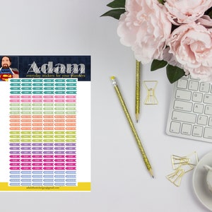 May include: A printable sheet of colorful planner stickers with various labels, including "Exam", "Project Due", "Goal", "Study", and "Homework". The sheet also features a cartoon illustration of a superhero with the text "The Sticker Guy" and "everyday stickers for your planners".