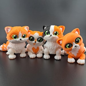 May include: Four small, hand-painted, orange, black, and white cat figurines with large eyes. The cats are in a row, facing forward.