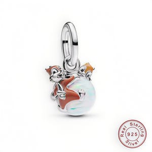 May include: A sterling silver charm featuring two cartoon chipmunks in brown and orange, hugging a white, iridescent orb. The charm has a silver loop for attachment. The charm is marked with "925" for sterling silver.