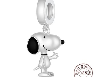 May include: A silver charm featuring Snoopy, the cartoon dog, with a black ear and nose, and a smiling face. The charm has a loop at the top for attaching to a bracelet or necklace. The charm is made of sterling silver.