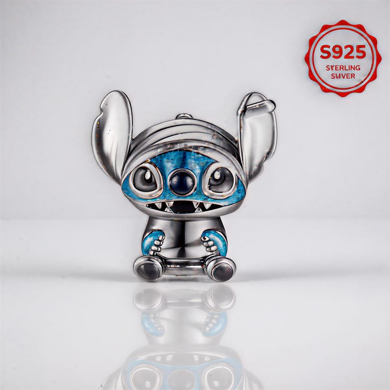 May include: A silver-colored charm featuring a cartoon character with large ears, blue accents, and a toothy grin. The charm has a blue face and hands, and the text "S925 STERLING SILVER" is in a red circle.