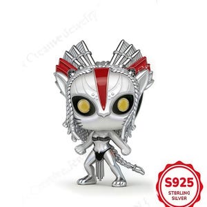Pode incluir: Estatueta prateada com design estilizado, com rosto felino, olhos amarelos grandes e detalhes vermelhos. A figura usa um biquíni preto e tem uma cauda. Na base, um círculo vermelho com o texto "S925 STERLING SILVER".