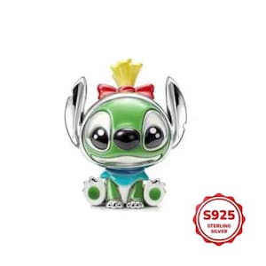 May include: A sterling silver charm depicting a green alien character with large black eyes, silver ears, and a yellow tuft of hair. The charm has a red bow and a blue collar. The charm is marked with "S925 STERLING SILVER".