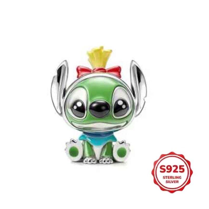 May include: A sterling silver charm depicting a green alien character with large black eyes, silver ears, and a yellow tuft of hair. The charm has a red bow and a blue collar. The charm is marked with "S925 STERLING SILVER".
