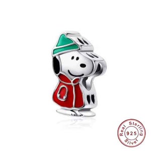 May include: A silver charm depicting a cartoon character wearing a red coat and a green hat. The charm has black details and a smiling face. A collectible item.