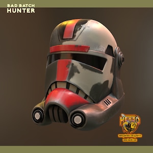 May include: A close-up of a red, black, and white painted helmet with a visor. The helmet has a worn and weathered look, with scratches and scuffs. The helmet is labeled "BAD BATCH HUNTER".