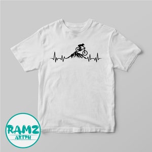 May include: White t-shirt with a black graphic of a mountain biker riding up a mountain with a heartbeat line below.