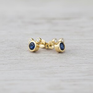 Delicate gold plated earrings with blue cubic zirconia center and white CZ sparkle. Lightweight, stylish, and handmade.
delicate earrings, CZ jewelry, gold studs, handmade minimal, blue stone