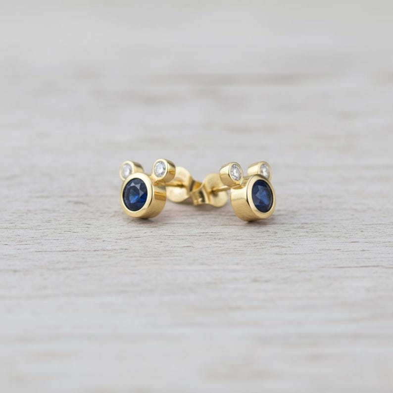 Delicate gold plated earrings with blue cubic zirconia center and white CZ sparkle. Lightweight, stylish, and handmade.
delicate earrings, CZ jewelry, gold studs, handmade minimal, blue stone
