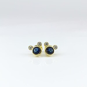 Tiny gold-plated earrings set with sapphire-blue cubic zirconia stones. Perfect small earrings for women, elegant and minimal.
 tiny earrings, CZ studs, gold jewelry, sapphire blue, women earrings