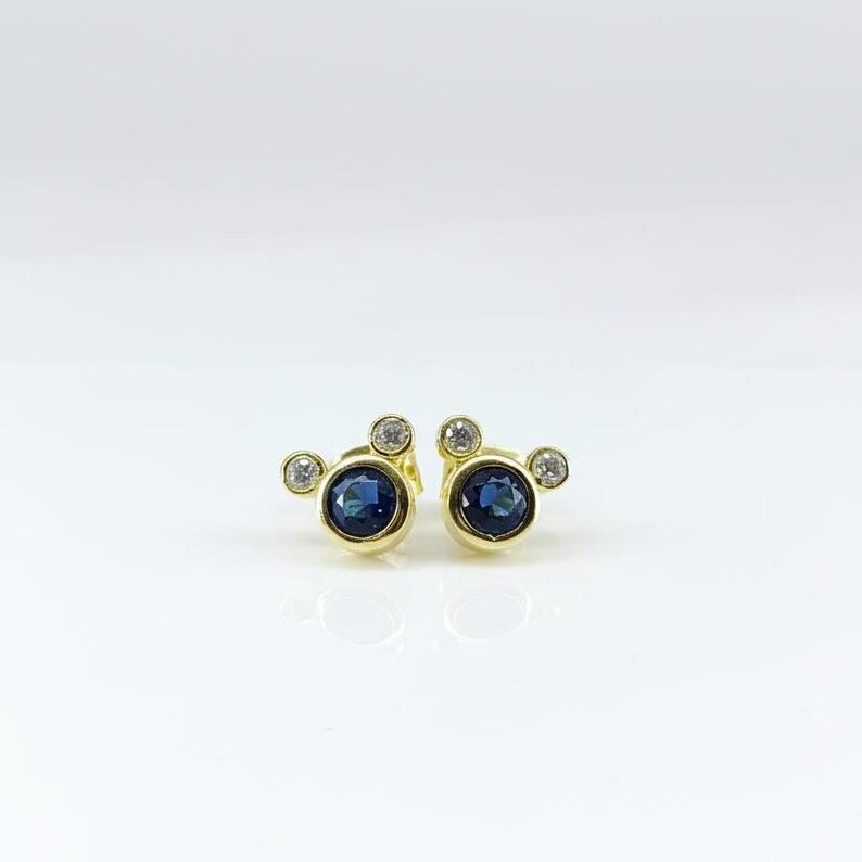 Tiny gold-plated earrings set with sapphire-blue cubic zirconia stones. Perfect small earrings for women, elegant and minimal.
 tiny earrings, CZ studs, gold jewelry, sapphire blue, women earrings